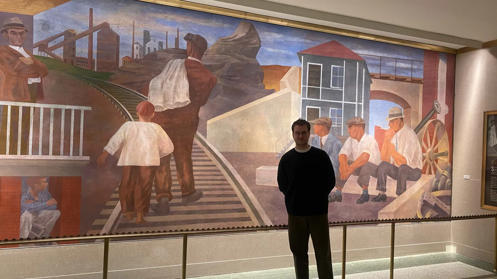Schuyler standing in front of mural
