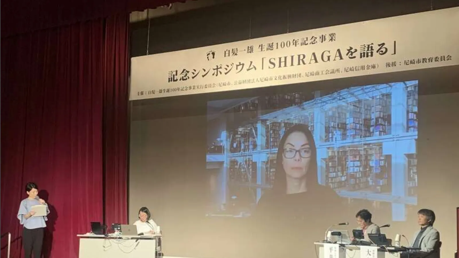 Virtual Talk with Namiko Kunimoto on screen in auditorium in Japan