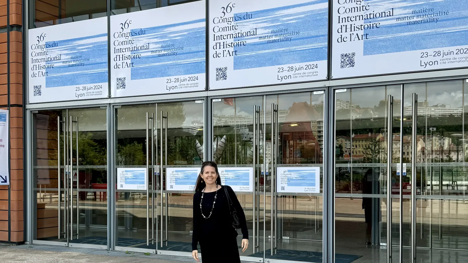 Karin Flora standing outside the entrance to the 36th Comité International d’Histoire de l’Art World Congress