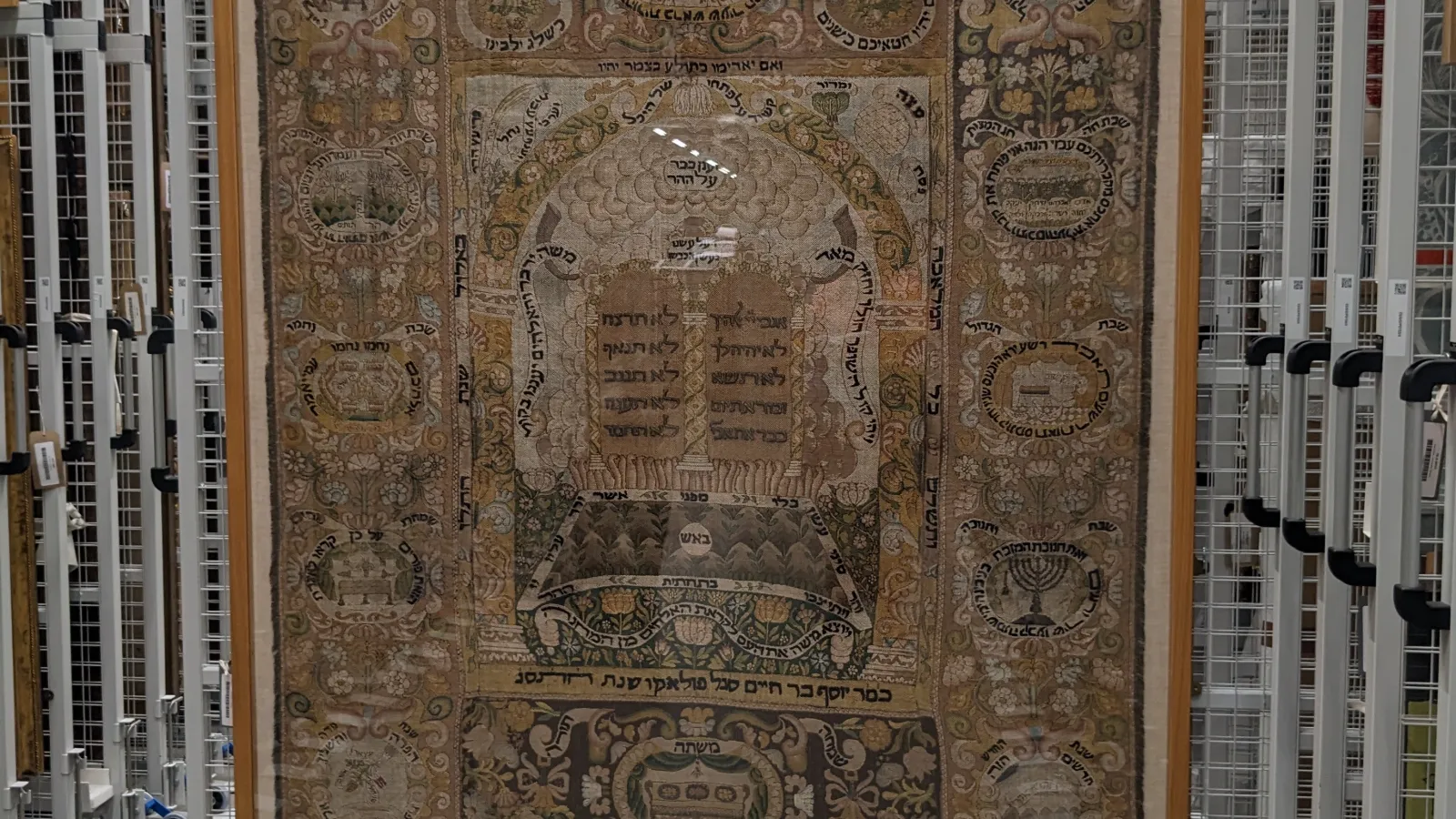 a historic Torah ark curtain hanging in museum archive