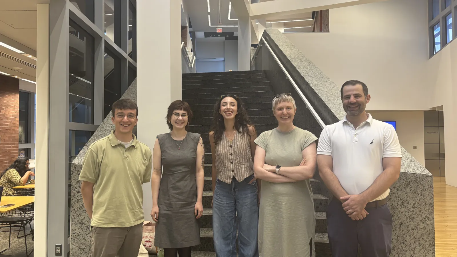 Five new PhD students stand inside the Wex