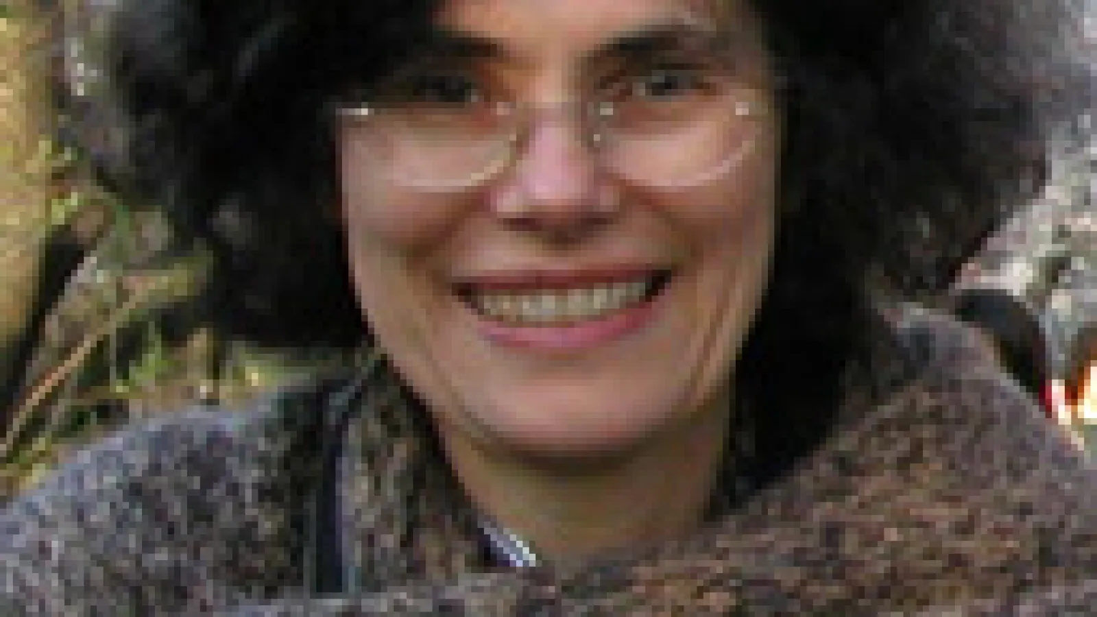 Julia Andrews smiling wearing glasses and a wool scarf