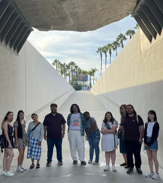 Group of people standing under a structure in the shade